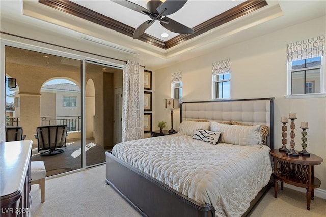 carpeted bedroom featuring a tray ceiling, ornamental molding, and ceiling fan