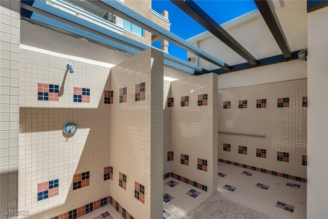 bathroom with beam ceiling and a shower