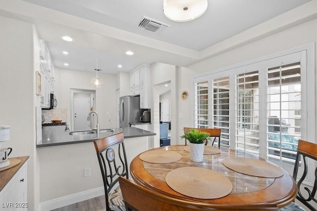 dining room with hardwood / wood-style flooring and sink