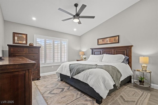 bedroom featuring light hardwood / wood-style flooring, vaulted ceiling, and ceiling fan