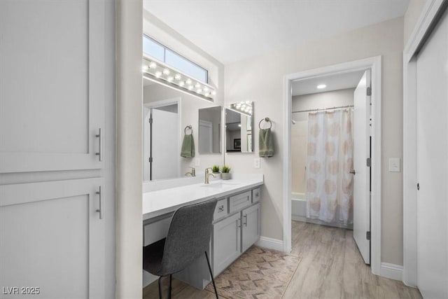 bathroom featuring vanity, shower / bathtub combination with curtain, and hardwood / wood-style floors