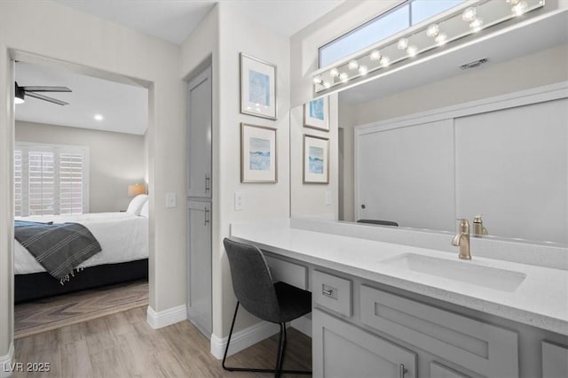 bathroom featuring ceiling fan, vanity, and hardwood / wood-style floors