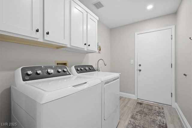 laundry room with cabinets, light hardwood / wood-style floors, and independent washer and dryer