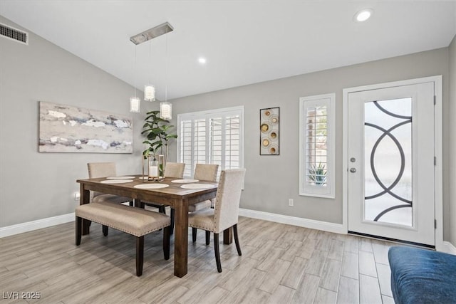 dining area featuring vaulted ceiling and light wood-type flooring