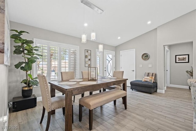 dining room featuring lofted ceiling and light hardwood / wood-style flooring