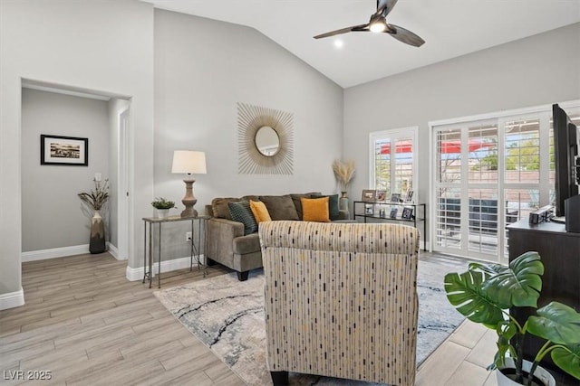 living room featuring vaulted ceiling, ceiling fan, and light hardwood / wood-style flooring