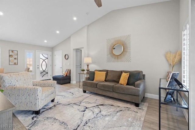 living room featuring lofted ceiling, a wealth of natural light, and light hardwood / wood-style flooring