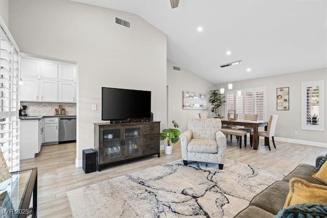 living room with high vaulted ceiling and light wood-type flooring