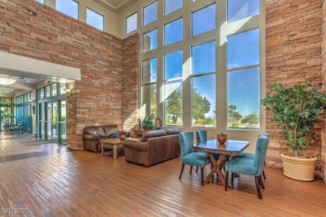 unfurnished dining area featuring a towering ceiling and wood-type flooring