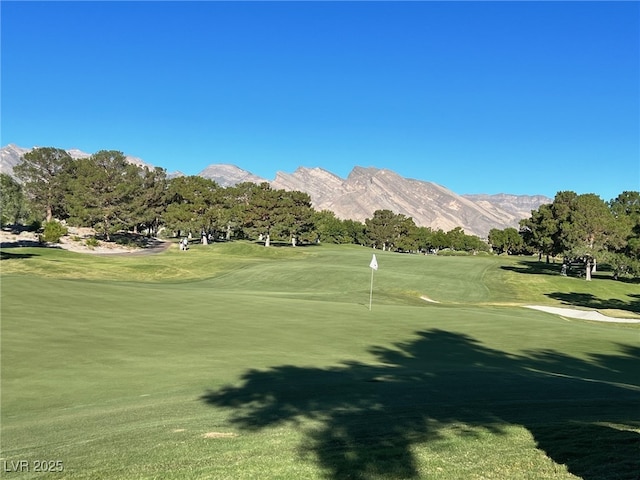 surrounding community with a mountain view and a yard