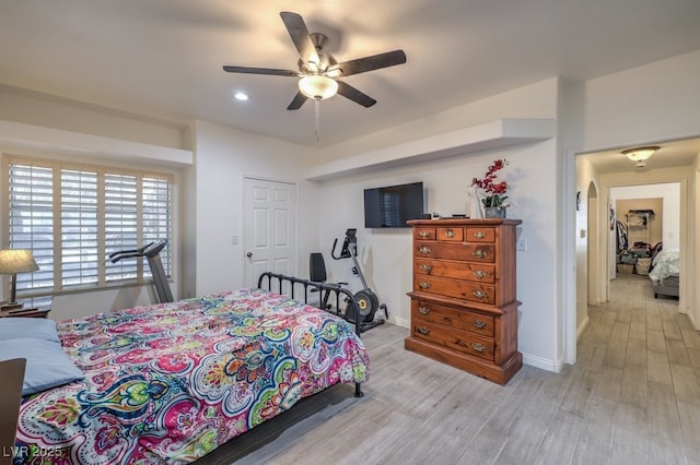 bedroom featuring arched walkways, recessed lighting, a ceiling fan, baseboards, and light wood-style floors