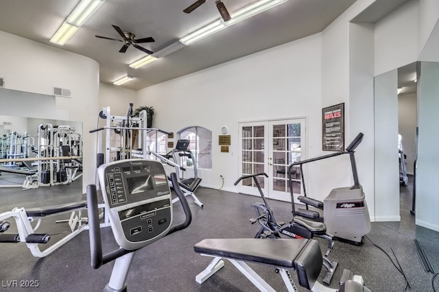 gym with french doors, visible vents, a towering ceiling, a ceiling fan, and baseboards