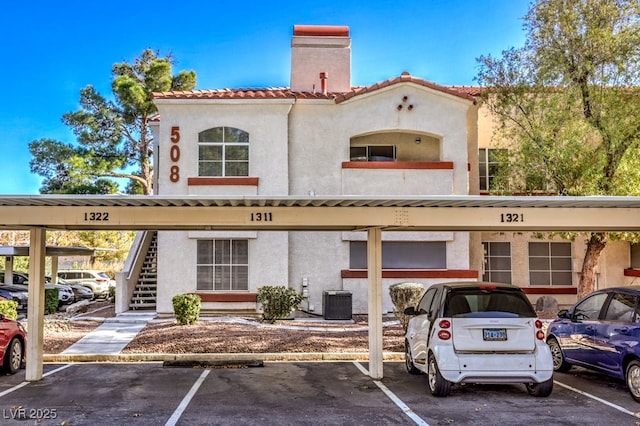 view of property with stairs and covered parking