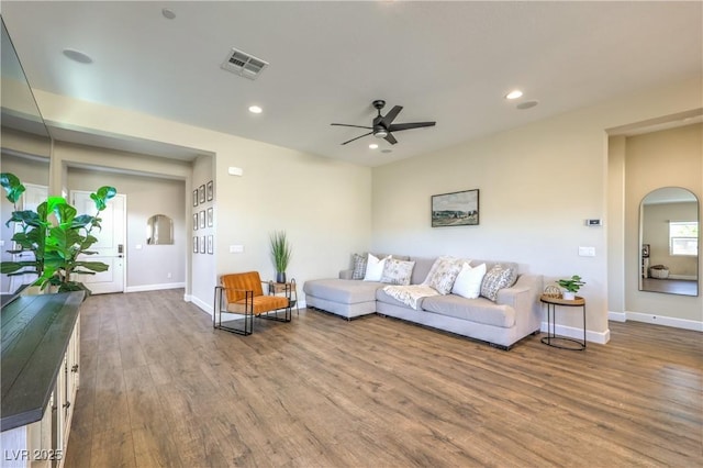 living room with wood-type flooring and ceiling fan