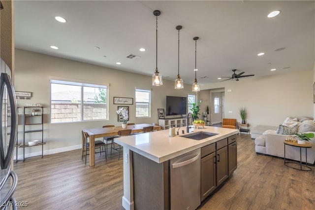 kitchen featuring appliances with stainless steel finishes, an island with sink, dark hardwood / wood-style floors, and sink