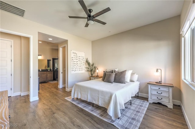 bedroom with dark wood-type flooring, ensuite bath, and ceiling fan