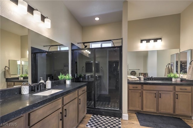 bathroom with vanity, a shower with door, and wood-type flooring