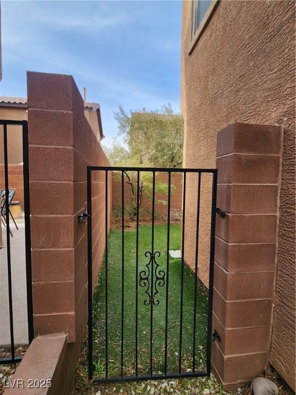 view of gate with a lawn