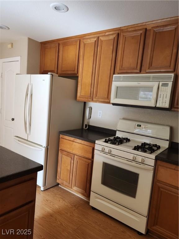 kitchen featuring white appliances and dark wood-type flooring