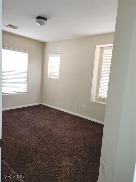 empty room featuring dark colored carpet