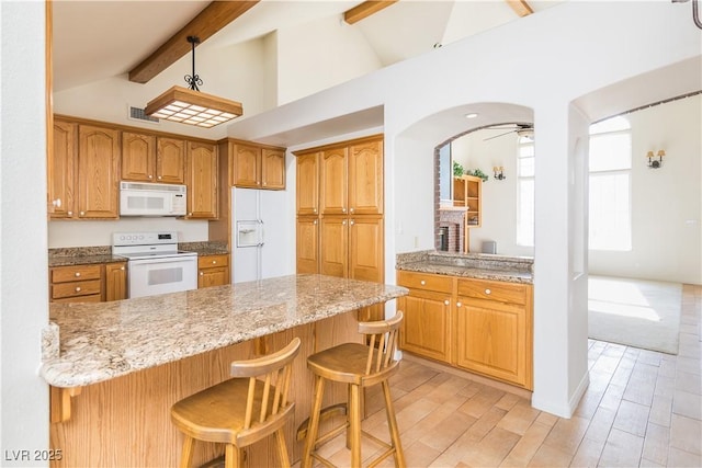 kitchen featuring white appliances, vaulted ceiling with beams, a kitchen breakfast bar, light stone countertops, and kitchen peninsula