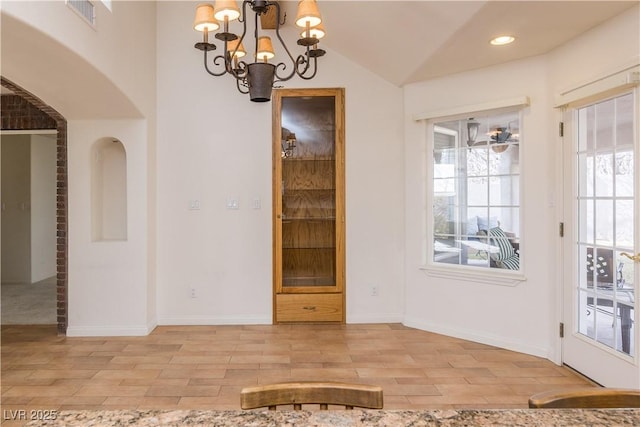 unfurnished dining area featuring an inviting chandelier, lofted ceiling, and light hardwood / wood-style floors