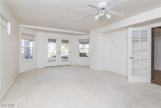 carpeted empty room with french doors and ceiling fan