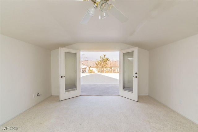 additional living space with vaulted ceiling, light colored carpet, french doors, and ceiling fan