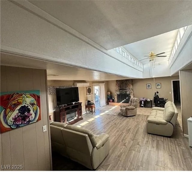 living room with ceiling fan, a fireplace, and hardwood / wood-style floors