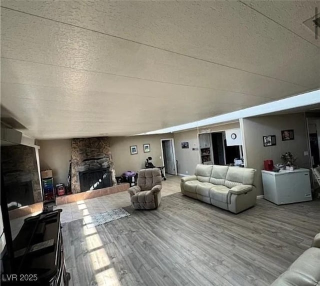 living room featuring hardwood / wood-style flooring, a textured ceiling, and a fireplace