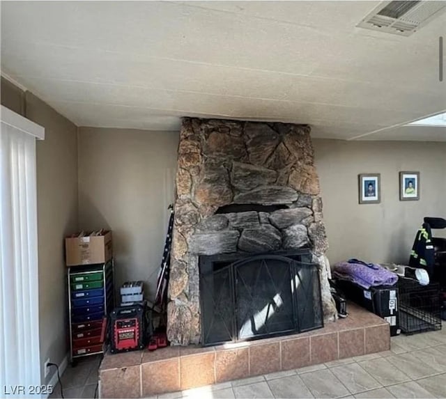 interior details featuring a tile fireplace