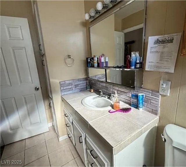 bathroom featuring tile patterned floors, toilet, decorative backsplash, and vanity