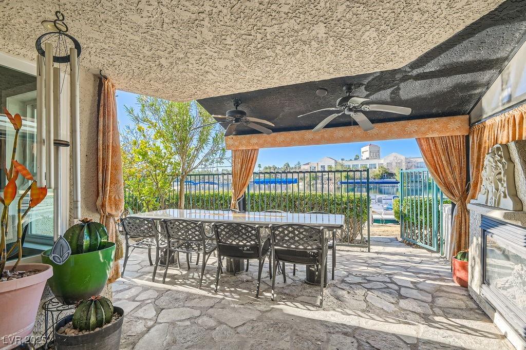 view of patio with a water view and ceiling fan