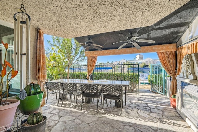 view of patio with a water view and ceiling fan