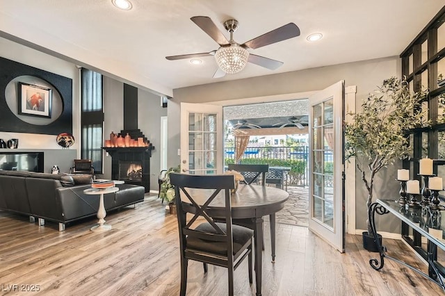 dining room featuring ceiling fan, light wood-type flooring, and french doors