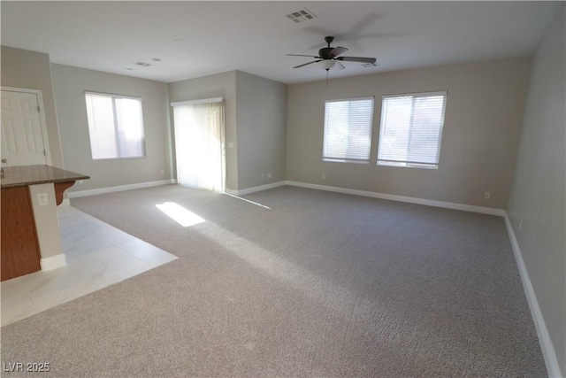 unfurnished living room featuring light colored carpet and ceiling fan