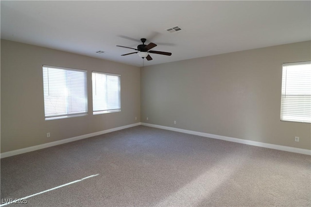 carpeted empty room with ceiling fan and a healthy amount of sunlight