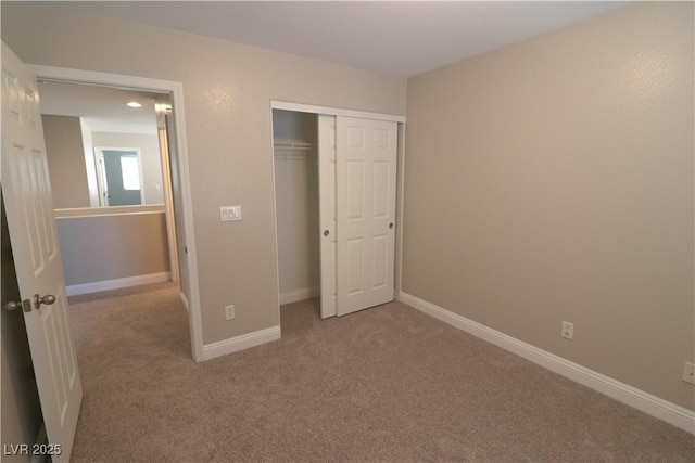 unfurnished bedroom featuring light colored carpet and a closet