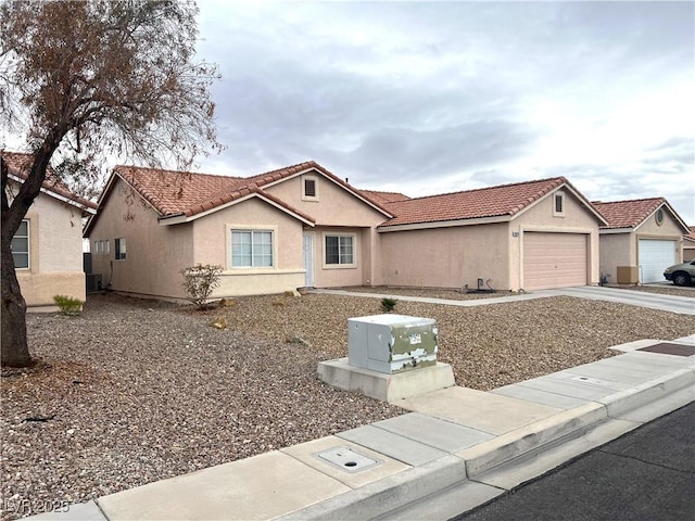 view of front of property featuring driveway, a tile roof, an attached garage, central air condition unit, and stucco siding