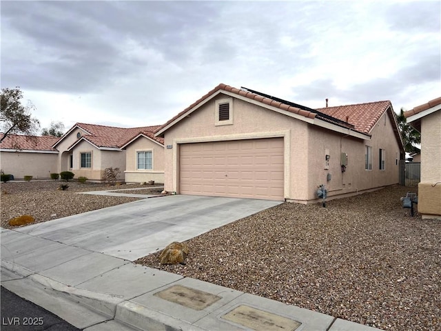 ranch-style home with an attached garage, driveway, a tiled roof, and stucco siding