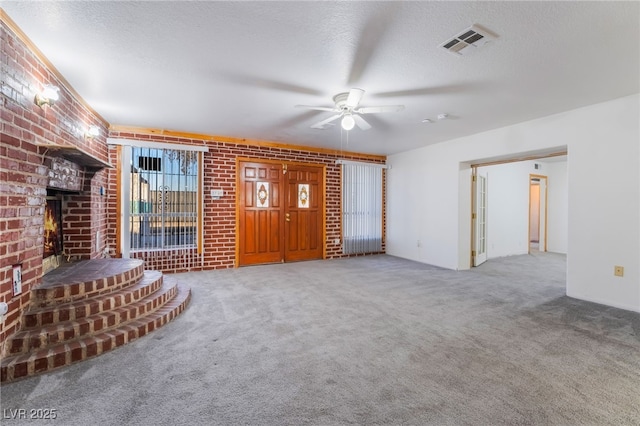 unfurnished living room featuring brick wall, a brick fireplace, and a textured ceiling