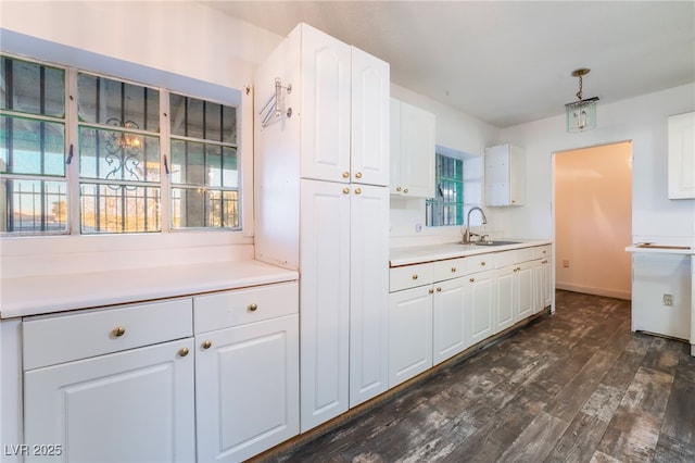 kitchen with white cabinetry, sink, dark hardwood / wood-style flooring, and decorative light fixtures