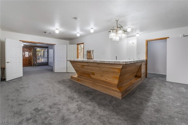 bar featuring hanging light fixtures and dark colored carpet