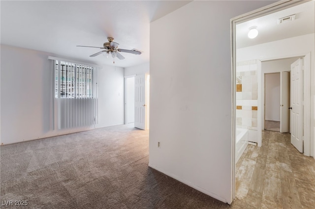 empty room featuring light colored carpet and ceiling fan