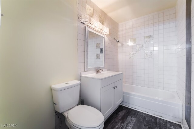 full bathroom with tiled shower / bath, wood-type flooring, toilet, and vanity