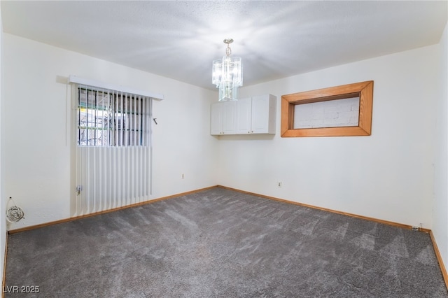 unfurnished room featuring an inviting chandelier and carpet