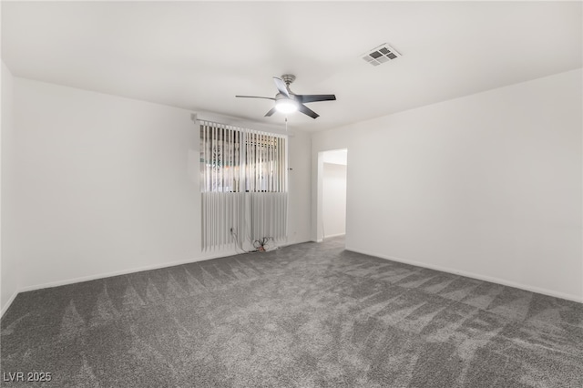 unfurnished room featuring ceiling fan and dark carpet