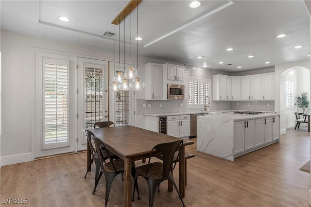 dining space featuring wine cooler, sink, and light hardwood / wood-style floors