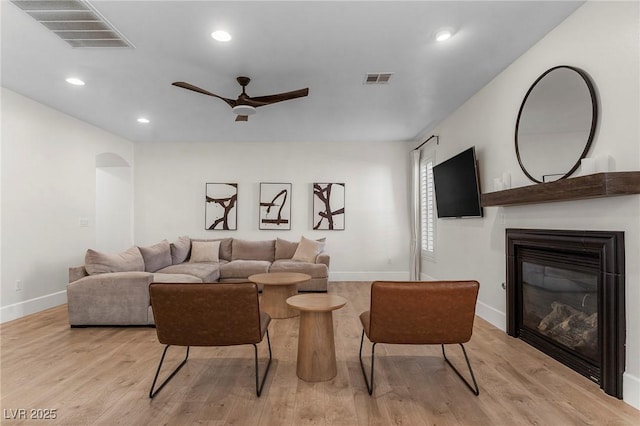 living room with light hardwood / wood-style floors and ceiling fan