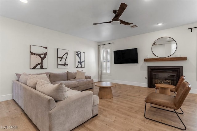 living room featuring ceiling fan and light wood-type flooring